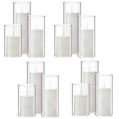 six clear glass vases with white candles in the middle and one candle on each side