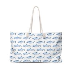 "This large beach tote bag is roomy enough to hold it all - hat, towels, sunscreen and all you need for a day at the beach.  Made from hardy poly poplin, this bag features a wide opening to easily pull things in and out, and a T-bottom so the bag sits flat when you put it down. Cotton rope handles thread through metal grommets and tied in a knot give the bag a relaxed coastal feel. The Carry All Tote features cute blue fish swimming  all over both sides of the bag. The bag fabric is white with a Summer Weekend Cotton Beach Bag, Large Beach Bag With Large Capacity, Large Beach Bag For Summer, Large Capacity Beach Bag For Summer Weekend, White Beach Bag For Vacation, Cotton Bucket Bag For Vacation, Summer Weekend Beach Tote Bag, White Coastal Beach Bag For Travel, White Canvas Beach Bag