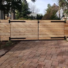 a wooden fence is shown in front of a brick walkway