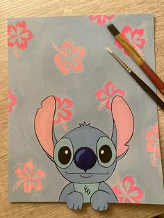 a painting of a koala with pink flowers on it and a paintbrush next to it