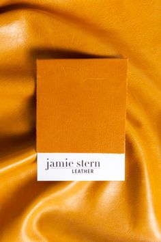 A cutting of Jamie Stern Trento Sunflower leather is pictured on top of a full hide of the same leather. Trento Sunflower is a rich, golden yellow. Leather Photography, Poster Background Design, Yellow Aesthetic, Leather Furniture, The Square, Orange Leather, Pull Up, Leather Design