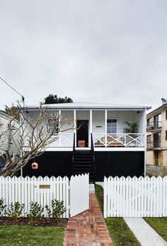 a black and white house with a brick walkway