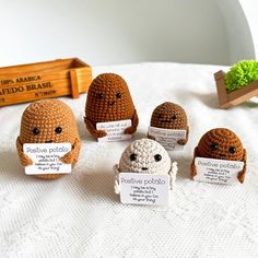 small crocheted stuffed animals sitting on top of a white bed covered in paper