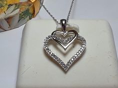 This Pretty Estate Necklace features a Heart in a Heart with the larger one in White Gold and 45) small Natural white Diamonds, all prong set. The smaller heart is done in polished Yellow Gold, ant the entire pendant measures aprox 11/16" X 11/16" and a drop of 7/8" that includes the bail. The Pendant & 18" light link chain weighs aprox 2.332 grams of Solid (Stamped 10Kt on the bail, & 10Kt Fremada on chain tag) 10Kt White Gold chain & 10Kt 2Tone Pendant. This Pretty Estate Diamond Necklace is priced in our store at $2999.00. *All of our Vintage and Estate Jewelry is sold as is and has been checked for Security on gems by CERES, and or Gold/925 purity, and Polished for a new home. Any defects or flaws are pointed out to the best of our ability and all prices ready to sell!  We are a store White Double Heart Diamond Accent Necklace, White Diamond Cut Double Heart Necklace, White Double Heart Diamond Cut Necklace, White Heart-shaped Diamond Necklace For Anniversary, White Diamond Open Heart Necklace For Anniversary, White Open Heart Diamond Necklace For Anniversary, Brilliant Cut Heart Necklace For Anniversary, White Diamond Heart Pendant Necklace For Anniversary, White Diamond Necklace With Heart Charm For Anniversary