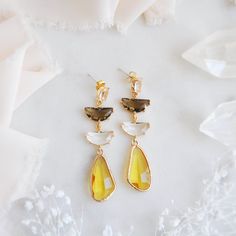 "These gorgeous boho bridal earrings feature unique faceted yellow drops which are reminiscent to flower petals or even fluttering butterfly wings! These eye catching statement earrings are the perfect accessory for wearing in an updo hair style for your boho wedding, a birthday gift for your best friend or to add a touch of sparkle for a special occasion this summer! These dangle earrings are created with sterling silver and oval faceted glass with a golden frame. Your beautiful yellow and hazel brown earrings will arrive suitably gift wrapped ready for gift giving. Measurements: The length of the boho bridal earrings hang just under 2.5\" long Metals: 18k gold plated brass  925 sterling silver plated earring posts For a similar pair of earrings with pink and hazel brown: https://www.etsy Yellow Teardrop Earrings For Wedding, Yellow Dangle Chandelier Earrings For Wedding, Yellow Dangle Earrings For Wedding, Faceted Yellow Jewelry For Wedding, Yellow Faceted Dangle Earrings, Yellow Teardrop Faceted Earrings, Yellow Wedding Earrings With Ear Wire, Yellow Ear Wire Earrings For Wedding, Yellow Earrings With Ear Wire For Wedding