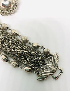 Excellent vintage 10 strand chain bracelet and earrings demi/set. Beautiful silver tone chain link brooch... 2 chains are beads in etched and smooth... plus several different chain styles make up the bracelet with ornate ends. Matching earrings with rope chain border same as in bracelet. Bracelet measures 7 1/2 inches long by just over 2 inch wide. Has secure fold over clasp. The earrings are clip backs which are secure and measure 1 1/8 inch across. All in excellent vintage condition condition Interchangeable Earrings, 1960s Jewelry, Vintage Designer Jewelry, Multi Strand Bracelet, Wide Bracelet, Strand Bracelet, Vintage Designer, Matching Bracelets, Rope Chain