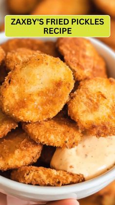 a bowl filled with fried pickles and sauce