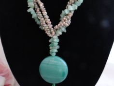 This unique polished green stone and exotic shell necklace is made of all nature materials (excluding the clasp) that have been polished and shined into a gorgous piece of jewelry.  This piece is made of green stones and exotic shells.  It was hard to capture the green in the photos, but it is what i would call a seafoam green with more green than blue.  It has a barrel clasp that screws together so it is secure.  What a wonderful piece of nature to wear!This piece is unsigned.  It is in excelle Amazonite Necklace With Natural Stones, Elegant Green Necklace For Beach, Green Pendant Necklace With Stones, Green Shell-shaped Jewelry For Gifts, Green Turquoise Pendant Necklace With Gemstone Beads, Green Shell Jewelry For Gifts, Green Turquoise Long Necklace With Gemstone Beads, Green Shell Bohemian Jewelry, Green Amazonite Necklaces