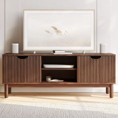 a wooden entertainment center with two drawers and an art print on the wall behind it