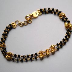 "Layered gold chain bracelet with black beads and gold balls, handcrafted with love and care, this is a very comfortable bracelet. A perfect accessory for everyday wear. Lightweight and stylish..! Available in single strand or double strand. * Length : 5.5\" to 9\" + 0.5\" extender eg : 6\" length will fit wrist size of 6\"- 6.5\" * Gold : 18k Solid Yellow Gold * Gold Weight - 4.5 gms approx for 6\" inches double strand with extender - For longer/shorter length, please ask for a quote before pla Black Beads Bracelet Gold For Women, Black Beads Bracelet Gold, Bracelet With Black Beads, Gold Bracelet Indian, Mangalsutra Bracelet, Bracelet Indian, Mangal Sutra, Black Beads Mangalsutra Design, Dainty Gold Bracelet