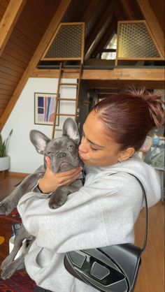 a woman holding a small dog in her arms