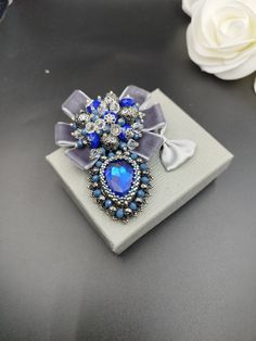 a blue and white brooch sitting on top of a table