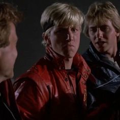 three men in leather jackets are talking to each other