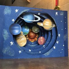 a cardboard box with an image of the solar system in it's center, on top of a table