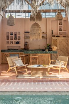 the inside of a house with wicker furniture and plants hanging from it's roof