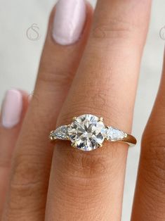 a woman's hand with a ring on it and a diamond in the middle