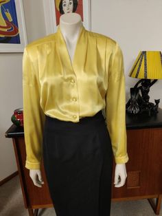 This is the second Peter Metchev label blouse that I'm listing. This one is a bright golden yellow polyester, soft and draping, with shoulder pads, long sleeves and a cuff, pleats at the shoulders and a button front. The condition is good except for a section on upper sleeve ( see photo ) Measurements are Shoulder to shoulder 42cm Bust 108cm Sleeves shoulder to cuff 60cm Length shoulder to hem 65cm Yellow Long Sleeve Party Tops, Elegant Yellow Blouse For Evening, Elegant Yellow Evening Blouse, Elegant Yellow Tops For Fall, Elegant Formal Yellow Blouse, Elegant Yellow Formal Blouse, Fitted Gold Top For Workwear, Elegant Yellow Formal Tops, Fitted Gold Tops For Work