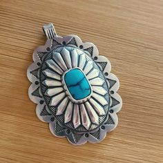 A big, beautiful sterling silver stamped concho pendant with turquoise. The pendant is stamped out in New Mexico and sent to me unfinshed.  I use hand tools to file and form it, solder and set the bezel and bale, then stamp, oxidize and polish it to a high shine. It is completely hand-finished by me here in bee-utiful Tucson, AZ. I've set a high-quality blue 12mm x 7mm turquoise cabochon in the center. I've also soldered the bale closed for security. The bale can accommodate a 3mm chain or a fat leather cord, or you can add it to your southwestern-style beaded necklace as you make it! Pendant measures approximately 2" long x 1 1/2" wide, and is stamped .925 on the back.  ♥ large pendant measures approximately 2" long x 1 1/2" wide ♥ stamped from 22 gauge sterling silver, sturdy but not too Bee Utiful, Rodeo Cowgirl, Southwest Jewelry, Western Rodeo, Southwest Style, Tucson Az, Southwestern Style, Leather Cord, New Mexico