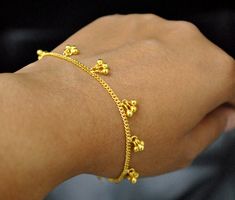 An Indian design with lovely shiny small gold beads/bells dangling in bunches of 3 on a dainty chain. Handcrafted with love and care, this is a very comfortable bracelet and a beautiful anklet. A perfect accessory for everyday wear. Lightweight and stylish..! * Gold Weight - 4.6 gms (length 7 inches) * Bracelet Length - 5 to 10 inches (Not including extra links) Find us on Instagram for exquisite designs: @abhikajewels Like us on Facebook: www.facebook.com/Abhikajewels Thank you for visiting our Bell Bracelet, Gold Bracelet Simple, Gold Jewels Design, Choker Necklace Designs, Beautiful Anklet, Beautiful Gold Necklaces, Handmade Gold Jewellery, Silver Jewellery Indian, Gold Anklet