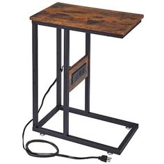 a wooden table with an electronic device on it's side and power cord attached to the top