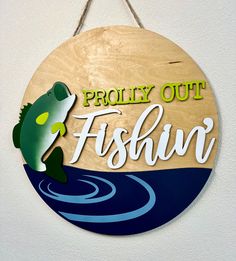 a wooden sign hanging from the side of a wall that says, proudly out fishing