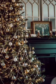 a decorated christmas tree in front of a fireplace