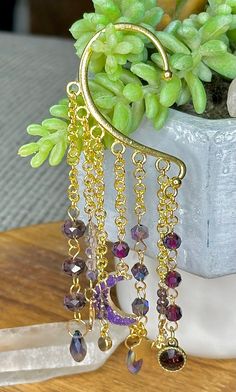 No piercing required with this beautiful beaded celestial ear cuff. Adorned with super flashy purple crystal beads. sold as a single Bohemian Adjustable Single Ear Cuff, Adjustable Bohemian Single Ear Cuff, Handmade Dangle Ear Cuff For Festivals, Bohemian Dangle Ear Cuff For Festivals, Bohemian Gold Dangle Ear Cuff, Gold Bohemian Dangle Ear Cuff, Bohemian Wire Wrapped Ear Cuff For Festival, Bohemian Dangle Earrings For Pierced Ears, Bohemian Wire Wrapped Festival Ear Cuff