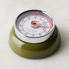 a green and white clock sitting on top of a table