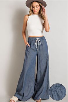 High waisted wide leg pants made with a smocked waist, waist tie, and side pockets in a washed denim. Tie Pants, High Waisted Wide Leg Pants, Wideleg Pants, Flannel Jacket, Elastic Waist Pants, Top Graphic Tees, Washed Denim, Romper With Skirt, Bottom Clothes