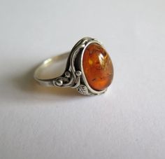 Reserved for Anastasia  This is a very attractive vintage gemstone ring. Made of solid sterling silver and in the Art Nouveau Style it has an ornate setting with a berry and leaf design and is bezel set with a natural golden amber gemstone.   Ring Size UK R.5 - US 8.75 Stamped -  925 Gemstone - 14X10 Natural Golden Amber Weight - 4g This ring is in nice vintage condition showing some expected signs of age such as mild tarnishing and fine surface scratches to the silver. I have greatly enlarged t Art Nouveau Ring, Gemstone Rings Vintage, Golden Amber, Amber Gemstone, Bezel Set Ring, Dope Jewelry, Art Nouveau Style, Silver Pieces, Dream Jewelry