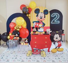 a mickey mouse birthday party with balloons and decorations