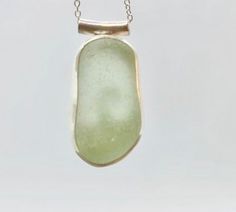 Individually handcrafted sterling silver pendant with a beautifully smooth seaglass nugget in seafoam green. The glass is sourced in Kintyre on the west coast of Scotland.  The naturally tumbled sea glass is set in a fine silver bezel and sits on a hand-sawn open backed sterling silver backplate with wave design, allowing the light to shine through. The pendant is suspended by a tube bail on a delicate sterling silver chain - please select your preferred length at checkout.  Makes an ideal gift for ladies or girls, wife or girlfriend - birthday, Christmas, anniversaries.  Other similar items available: Pendants: https://www.etsy.com/uk/shop/RockLobsterCrafts?ref=l2-shopheader-name§ion_id=24274610 Bangles & bracelets:  https://www.etsy.com/uk/shop/RockLobsterCrafts?ref=l2-shopheader-name§io Minimalist Green Glass Jewelry, Seafoam Sea Glass Jewelry For Gifts, Green Recycled Glass Pendant Jewelry, Elegant Green Sea Glass Jewelry, Minimalist Green Jewelry With Recycled Glass, Green Jewellery, Blue Sea Glass Necklace, Wave Pendant, Pebble Jewelry