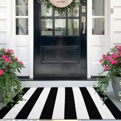 a black and white striped rug in front of a door with pink flowers on it