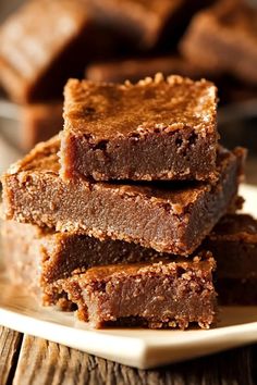 chocolate fudge brownies stacked on top of each other in front of a plate