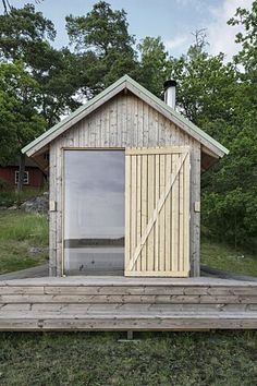 a small wooden building sitting on top of a lush green field