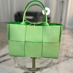 Brand New With Tag And Dustbag. Sold Out Everywhere. No Refunds Or Exchanges. This Is An Authentic Bottega Veneta Grained Calfskin Intrecciato Small Arco Tote In Pistachio And Parakeet. This Exceptional Handbag Is Crafted Of Grained Green Leather In A Maxi Weave Effect And Features Leather Top Handles. The Top Is Open To A Bright Green Suede Leather Interior. Size & Details Height: 20 Cm | 7.9" Width: 30 Cm | 11.8" Depth: 11.5 Cm | 4.5" Handle Drop: 15 Cm | 5.9" Tie Fastening Twin Top Handles De High-end Square Bag With Handle Drop, Luxury Square Box Bag With Handles, High-end Green Box Bag With Top Carry Handle, High-end Green Box Bag For Shopping, Designer Green Box Bag With Top Carry Handle, Designer Bags With Braided Handles And Top Handle, Designer Bags With Top Handle And Braided Handles, High-end Green Bags For Shopping, High-end Green Shopping Bag