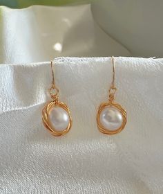 Experience the blend of traditional elegance and modern craftsmanship with our Handcrafted Wire-Wrapped Pearl Earrings. Each earring features a lustrous pearl encased in a delicate gold wire nest, offering a unique and stylish look. These earrings are perfect for those who appreciate the beauty of handcrafted jewelry and seek a versatile accessory that pairs well with both formal and casual outfits. Features: Material: High-quality pearl and gold-colored wire Design: Unique wire nest design arou Elegant Rose Gold Wire Wrapped Earrings, Elegant Wire-wrapped Yellow Gold Pearl Earrings, Elegant Wire Wrapped Earrings For Formal Occasions, Elegant Yellow Gold Wire Wrapped Pearl Earrings, Elegant Gold Wire Wrapped Jewelry, Elegant Gold-tone Hoop Earrings, Elegant Formal Wire Wrapped Jewelry, Formal Teardrop Wire Wrapped Earrings, Elegant Wire Wrapped Hoop Earrings For Anniversary