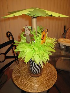 a table topped with a vase filled with flowers and an umbrella shaped decoration on top of it