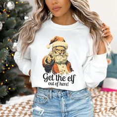 a woman wearing a santa clause shirt with the words get the elf out of here