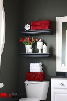 the bathroom is decorated with red and white towels, toiletries, and other accessories