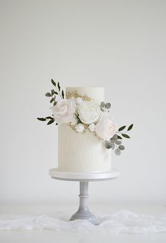 a white wedding cake with flowers on top