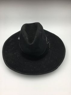 This men's Vintage Hat is a true masterpiece of Bavarian design. The alpine-inspired wide brim, coupled with the black felt material, gives this hat a timeless look that is perfect for any occasion. Circa 1880, this piece is not only stylish but also full of history and character.  Men's hunting hat circa late 1880.  This hunting hat was worn in the alpine areas of the Austro-Hungarian empire. Black wool felted hat with a wide brim edged in leather, deep crease in the crown, and trimmed black ve Vintage Black Fur Felt Fedora, Black Vintage Fur Felt Fedora, Black Fedora Hat For Ranch, Black Wool Hat Bands For Winter, Country Style Black Top Hat For Ranch, Black Fedora For Ranch, Black Fur Felt Top Hat For Winter, Wide Brim Black Hat For Ranch, Black Wide Brim Hat For Ranch