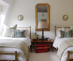 two beds in a bedroom with white walls