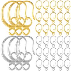 six pairs of gold, silver and black metal ear rings with swirl design on each side