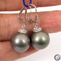 Lovely pair of solid 14K white gold Lever-back Continental Clip Earrings with total of 26 pieces sparkling tiny accent diamonds and Two- organic natural color, Tahitian SEAWATER cultured pearls from French Polynesia. Each of the huge genuine Tahitian pearl exhibits excellent high luster and thicker nacre with just a minimal natural spots/blemishing. Style: Drop/Dangle Metal Purity: 14K solid white gold. Genuine Diamonds: 26 / 0.180 ctw. Earring approx. Length (including pearl): 1.2 inches (3.1cm Silver Platinum Pearl Earrings For Anniversary, Anniversary White Gold Tahitian Pearl Earrings, Silver Round Tahitian Pearl Earrings, Silver Tahitian Pearl Round Earrings, Luxury Silver Tahitian Pearl Earrings, Classic Silver Tahitian Pearl Earrings, High Luster Silver Round Earrings, Elegant Silver Tahitian Pearl Earrings, Luxury Hypoallergenic Silver Earrings