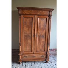 an old wooden armoire sitting on top of a brick floor