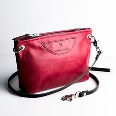 Our Everyday Collection of handbags reflects our task, offering tried + true styles + combinations that are timeless + classic. Colors + sizes to keep up with your effortless style + quality that holds up to your everyday adventures. The Tourist scales down the size of our most popular handbag, allowing you to take the essentials wherever life may lead. Adjustable cross-body strap, zipper closure and two lovely pockets. Available in Rocky and Ruby. Dimensions: 10" x 6" x 1 Features : -2 interior Everyday Pouch Bag With Palladium Hardware, Everyday Pouch Shoulder Bag With Palladium Hardware, Timeless Red Bag For Everyday Use, Timeless Bags With Palladium Hardware For Everyday Use, Pouch Shoulder Bag With Palladium Hardware, Timeless Pouch Bags For Everyday Use, Versatile Travel Bag With Palladium Hardware, Timeless Red Shoulder Bag For Daily Use, Everyday Clutch Shoulder Bag With Palladium Hardware