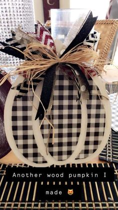 a black and white pumpkin sitting on top of a table next to a chair with the words another woodpunkin made