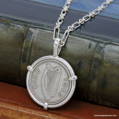 This is a custom order item. Your order will ship within 3-5 business days of payment confirmation. The coin pendant in the listing photos is an example of the finished piece. Excluding the year on the coin, your coin pendant will be the same design as the pictured pendant. Each pendant setting is made by hand (not a machine), and no two coins are exactly alike. If you are looking for a specific year, let me know, I may have it in my collection. This Irish Three Pingin rests in a handcrafted set Classic Sterling Silver Necklace With Coin Pendant, Hallmarked Coin Shaped Sterling Silver Necklaces, Vintage Sterling Silver Coin Jewelry, Heirloom Silver Necklace With Coin Pendant, Handmade Coin-shaped Sterling Silver Necklace, Handmade Sterling Silver Necklace For Commemoration, Classic Handmade Medallion Jewelry, Heirloom Sterling Silver Round Pendant Necklace, Heirloom Sterling Silver Pendant Necklace