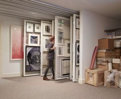 a man is walking through an open door in a room with stacks of boxes on the floor